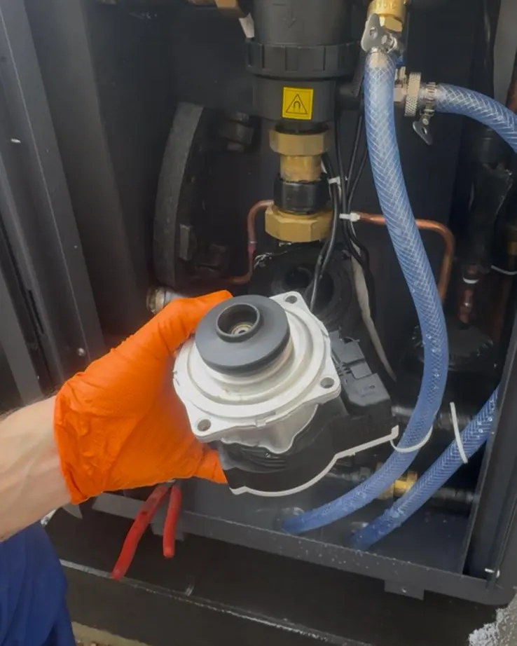 Monteur prüft ein Bauteil am Hydraulikmodul einer Wärmepumpe